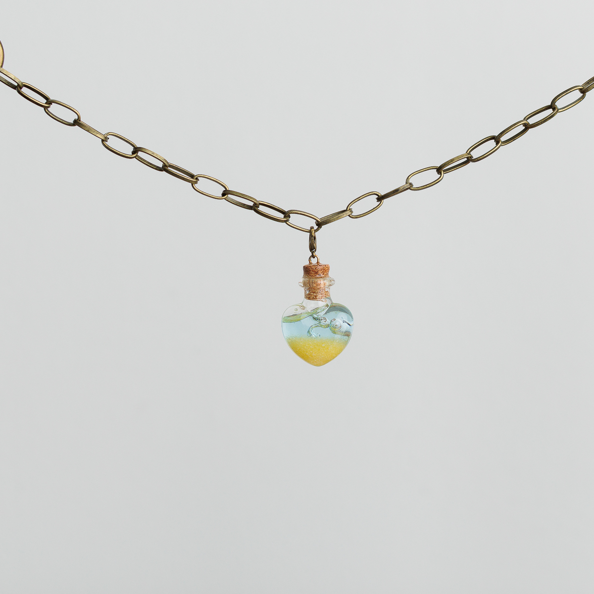 heart shaped bottle filled with material to look like sand and the ocean for a pirate cosplay outfit