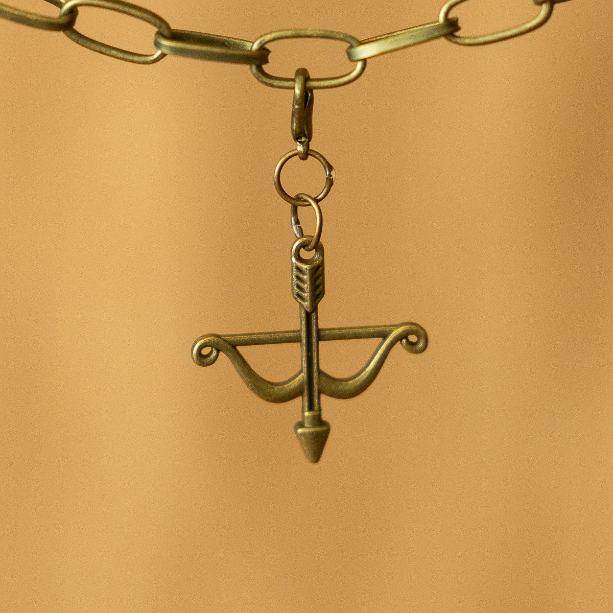 Bronze bow and arrow pointing downward